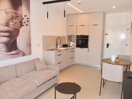 a living room with a couch and a table and a kitchen at דיויד רזידנט & ספא - by Desert 360 Mountain & sea view in Eilat