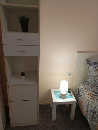 a bedroom with a bed and a table with a lamp at ADELA Apartment center city in Ruse