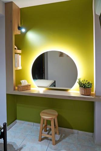 a bathroom with a circular mirror and a stool at Olive Groove Chios in Chios