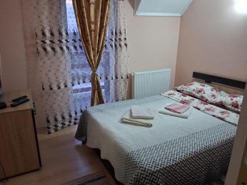 a bedroom with a bed with two towels on it at Cabana Vanatorului in Centru