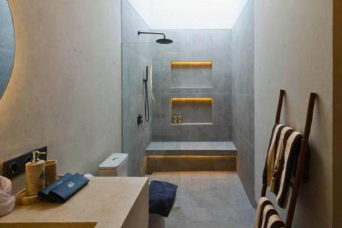a bathroom with a shower and a toilet and a sink at Bilha 1 BR Deluxe Suite Room in Kuta Lombok