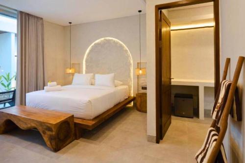 a bedroom with a large white bed and a mirror at Bilha 1 BR Deluxe Suite Room in Kuta Lombok