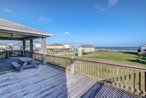 a wooden deck with a picnic table and the ocean at Molly's Place home in Crystal Beach
