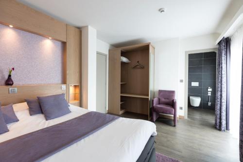 ein Schlafzimmer mit großem Bett und ein Badezimmer in der Unterkunft Hotel - La Grande Cure in Marcourt