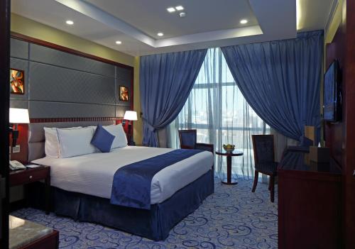 a hotel room with a bed and a large window at Intour Al Khafji Hotel in Al Khafji