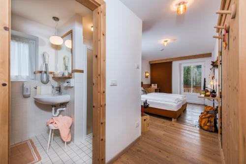 1 dormitorio y baño con lavabo. en Small & Lovely Hotel Zaluna, en Predazzo