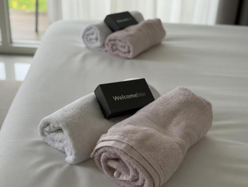 two towels and a book on a bed at Basic Mansion Mandalina in Šibenik