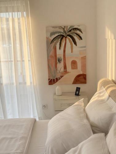a bedroom with a palm tree painting on the wall at Basic Mansion Mandalina in Šibenik