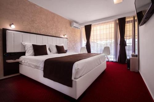 a bedroom with a large bed with a red carpet at Km ZerO - Vama Veche in Vama Veche