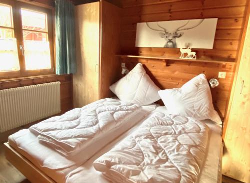a large bed in a room with a wooden wall at Ferienhaus Lauter 57 in Hayingen