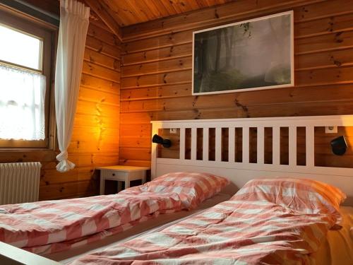a bedroom with two beds in a wooden cabin at Ferienhaus Neckar 43 in Hayingen