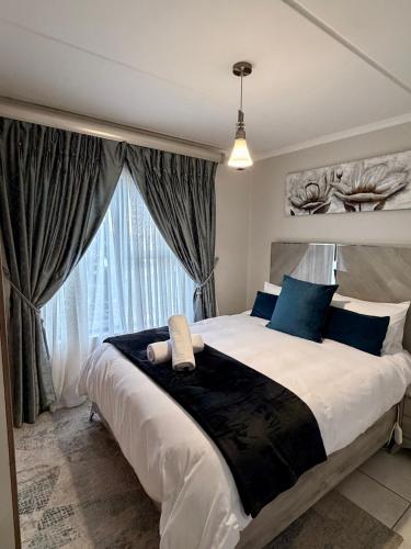 a bedroom with a large bed with a large window at Charming Oasis in the East in Boksburg