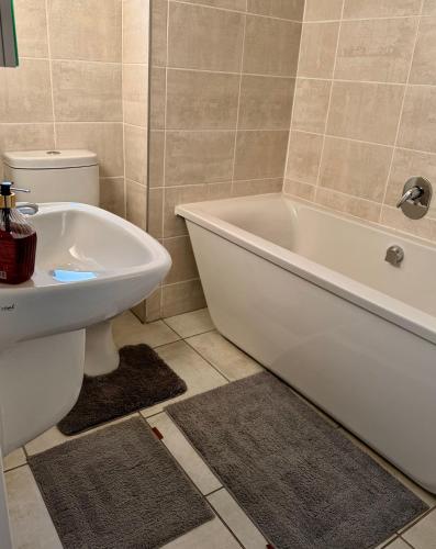 a bathroom with a tub and a toilet and a sink at Charming Oasis in the East in Boksburg