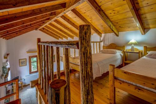 a log cabin bedroom with a bed and wooden ceilings at Manoli's House in Douliana
