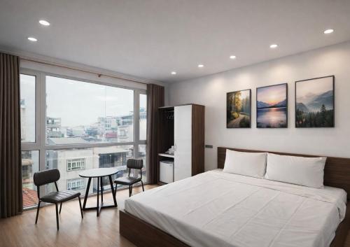 a bedroom with a bed and a table with chairs at Dreamora Signature Hotel in Hanoi