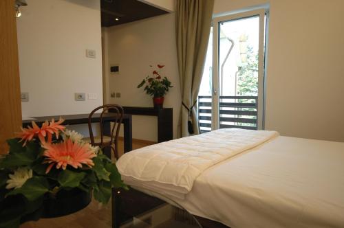 a bedroom with a bed and a window with flowers at Hotel La Pineta in Cerro Veronese