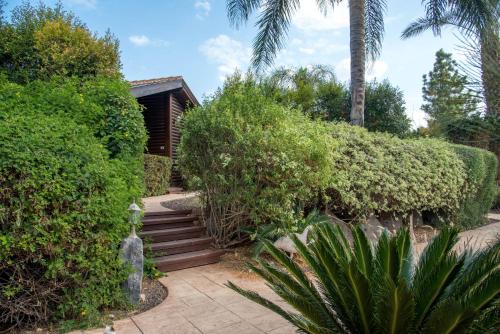 un jardín con una escalera que conduce a una casa en Pine Tree Cabin, en Ramot