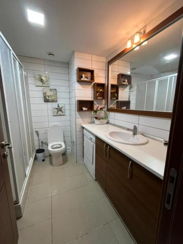 a bathroom with a toilet and a sink and a mirror at Premium Airport Residence 2 in Baku