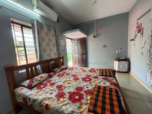 a bedroom with a bed with flowers on it at KENSON HOMESTAY in Mangalore