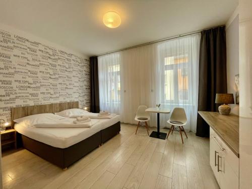 a bedroom with a bed and a table and chairs at Pension Phoenix in Znojmo