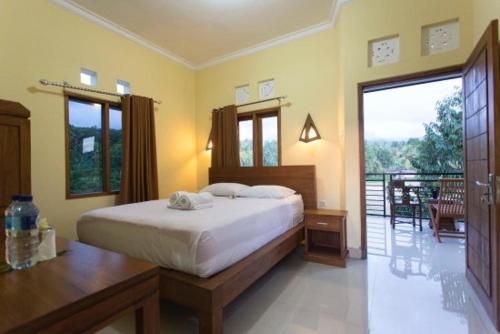 ein Schlafzimmer mit einem großen Bett und einem Balkon in der Unterkunft Yoga Homestay in Munduk