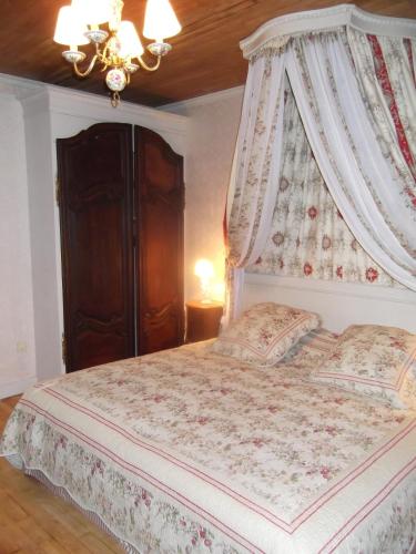 a bedroom with a bed with a canopy at Le Clos de la Font Queroy in Vouthon