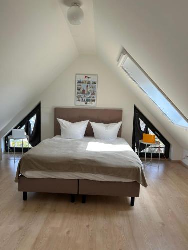 a bedroom with a large bed in a attic at Wellness- FeWo "Akelei" mit Sauna & Kamin in Zingst