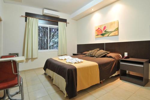 ein Schlafzimmer mit zwei Betten und einem Fenster in der Unterkunft Casa Nostra Hotel in Villa Carlos Paz