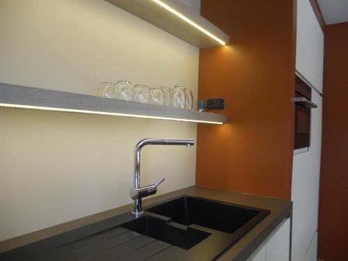 a kitchen with a sink and a shelf with glasses at Au Paradis Guesthouse in Waregem