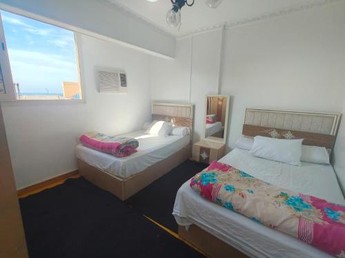a bedroom with two beds and a window at luxurious direct seaview apartment in Alexandria