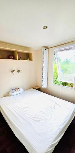 a large white bed in a room with a window at Mobil home 3 chambres - Homair parc des 7 fonts 3 étoiles in Agde
