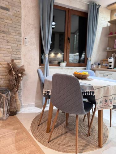 a table with two chairs and a bowl of fruit on it at Boutique apartment Bansko Bell Tower in Bansko