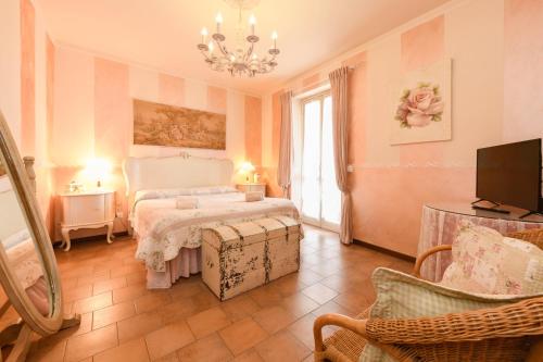 a bedroom with a bed and a tv and a couch at Relais De La Place - Downtown in Desenzano del Garda