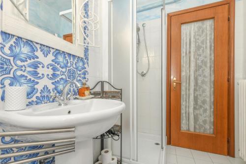 a blue and white bathroom with a sink and a shower at Relais De La Place - Downtown in Desenzano del Garda