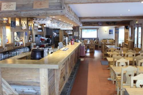 un bar dans un restaurant avec des tables et des chaises dans l'établissement Hôtel Restaurant U'Fredy, à La Clusaz