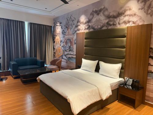 a bedroom with a king sized bed and a couch at City Center Suites in Bhatinda