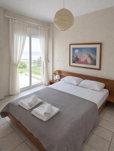 a bedroom with a large bed with towels on it at E&M Villa Sea View in Polychrono