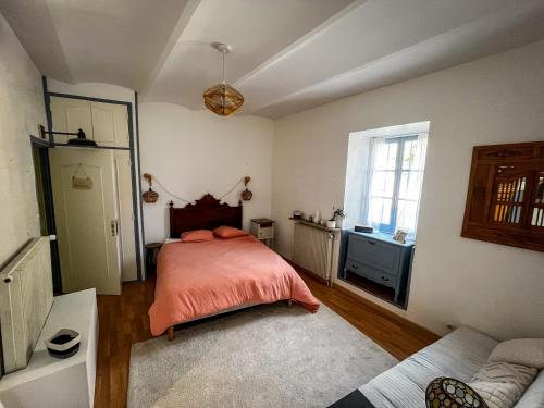 a bedroom with a bed with orange sheets and a window at Gite de La Cueille - Chambre double in Ribes