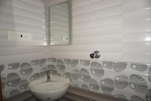 a bathroom with a sink and a mirror at Brindavana Stay in Bangalore