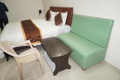 a bedroom with a bed and a chair and a table at Brindavana Stay in Bangalore