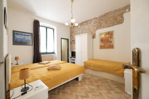 a bedroom with two beds and a brick wall at Apartment Poluotok in Zadar