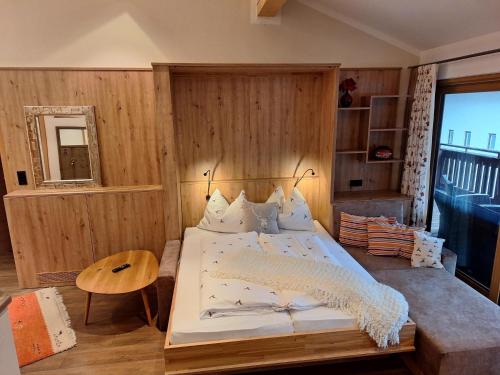 a bedroom with a bed with a wooden wall at Appartements Sportsüberl in Berwang