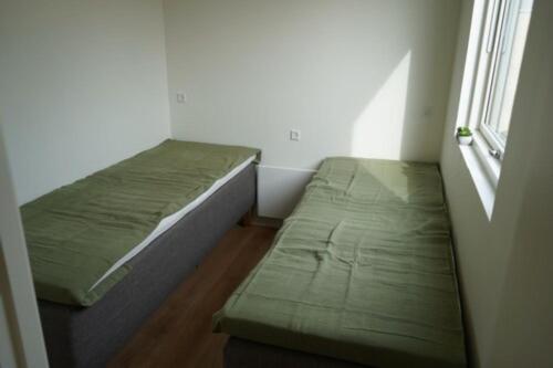 a small room with two beds and a window at Feriehusene Hedensted Centret - Sport, natur og velvære in Hedensted - Midtjylland
