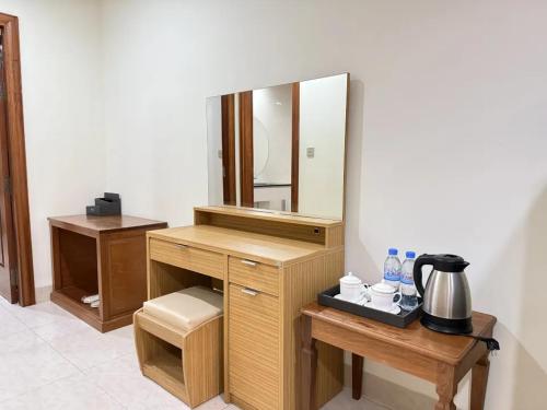 a vanity with a mirror and a table with a coffee maker at 中青秋果酒店金边王宫店 True Go Hotel in Phnom Penh
