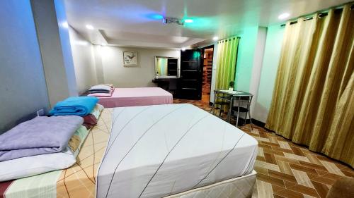 a room with two beds and a table in it at Bohol Ramyer Villa in Totolan