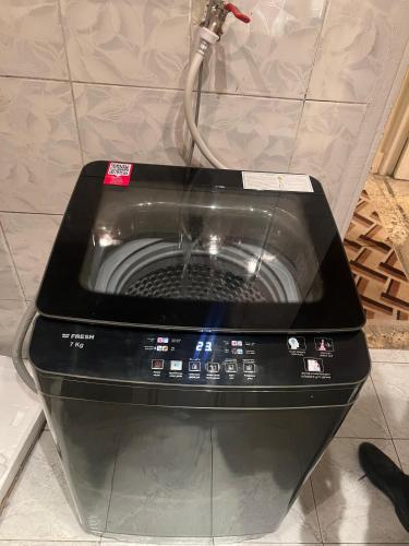 a washing machine with a cord hooked up to it at Anuket House in Naj‘ al Maḩaţţah