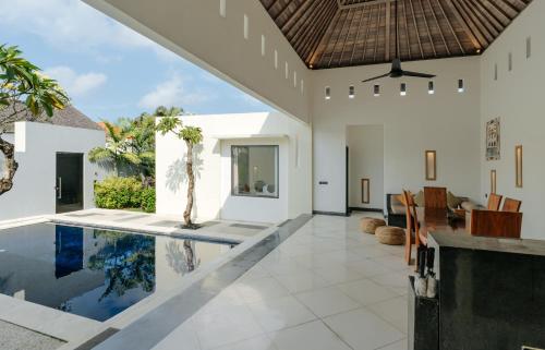 an open living room with a swimming pool and a house at The Seminyak Suites Private Villas in Seminyak