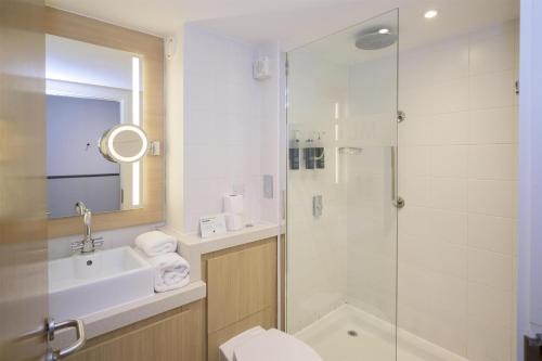 a bathroom with a shower and a toilet and a sink at DoubleTree by Hilton Coventry Building Society Arena in Coventry