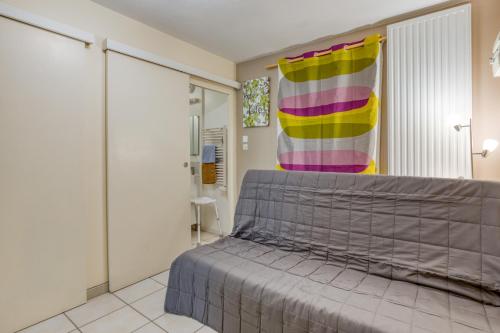 a bedroom with a bed and a colorful curtain at La Colline des Pins in Aniane
