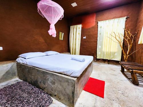 a bedroom with a bed with a pink balloon at Clay Hut by Ever Green Eco Resort in Wilpattu